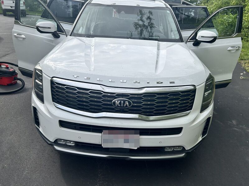 White Kia Telluride SUV detailed on site in the owner's driveway